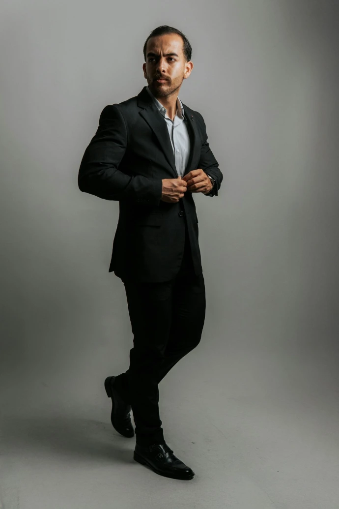 A man in a suit strikes a confident pose.